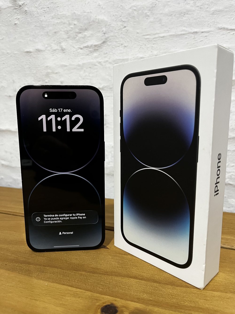 iPhone con su caja sobre una mesa de madera