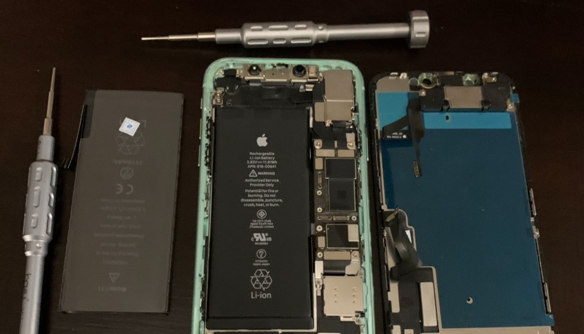 iPhone abierto con su batería, la placa y la pantalla separadas